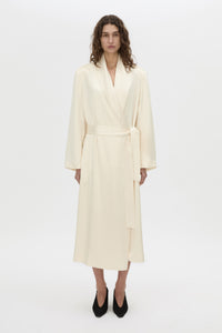 Front-styled view CAMILLA AND MARC Arion Shawl Collar Dress in cream with wrapped robe-style design.