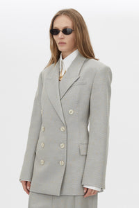 Three-quarter view CAMILLA AND MARC Aspira Blazer in Dusty Blue with a draped double‑breasted wool silhouette.