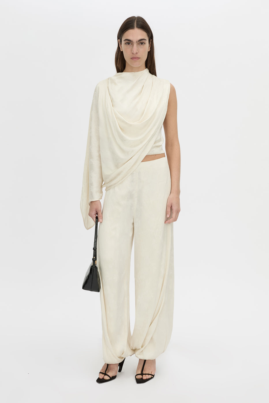 Front-styled view CAMILLA AND MARC Avis Drape Top in cream with asymmetric drape and cowl neckline.