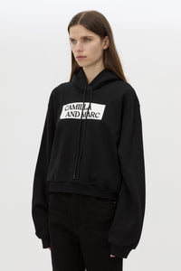 Cropped view CAMILLA AND MARC Carmont Graphic Hoodie in Black with boxy fit and black graphic logo.