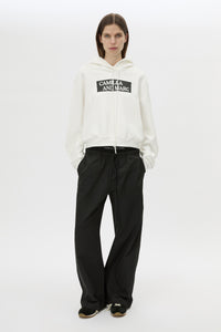 Front styled view CAMILLA AND MARC Carmont Graphic Hoodie in Soft White with boxy fit and black graphic logo.