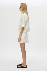 Side view CAMILLA AND MARC Chara Embroidered Cropped Shirt in Cream with short sleeves, lace hem and slight A‑line fit.