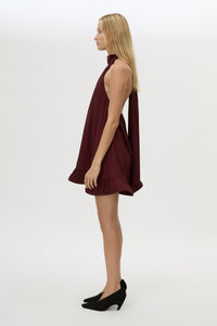 Side view CAMILLA AND MARC Elsen Halter Mini Dress in Burgundy with open back, tie‑up neck and fluted crinoline hem.