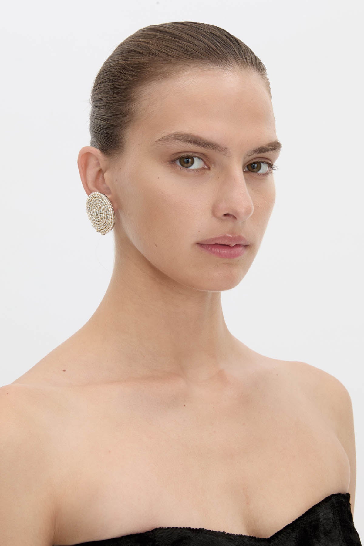 Side view CAMILLA AND MARC Irida Earrings in cream with spiral pearl design.