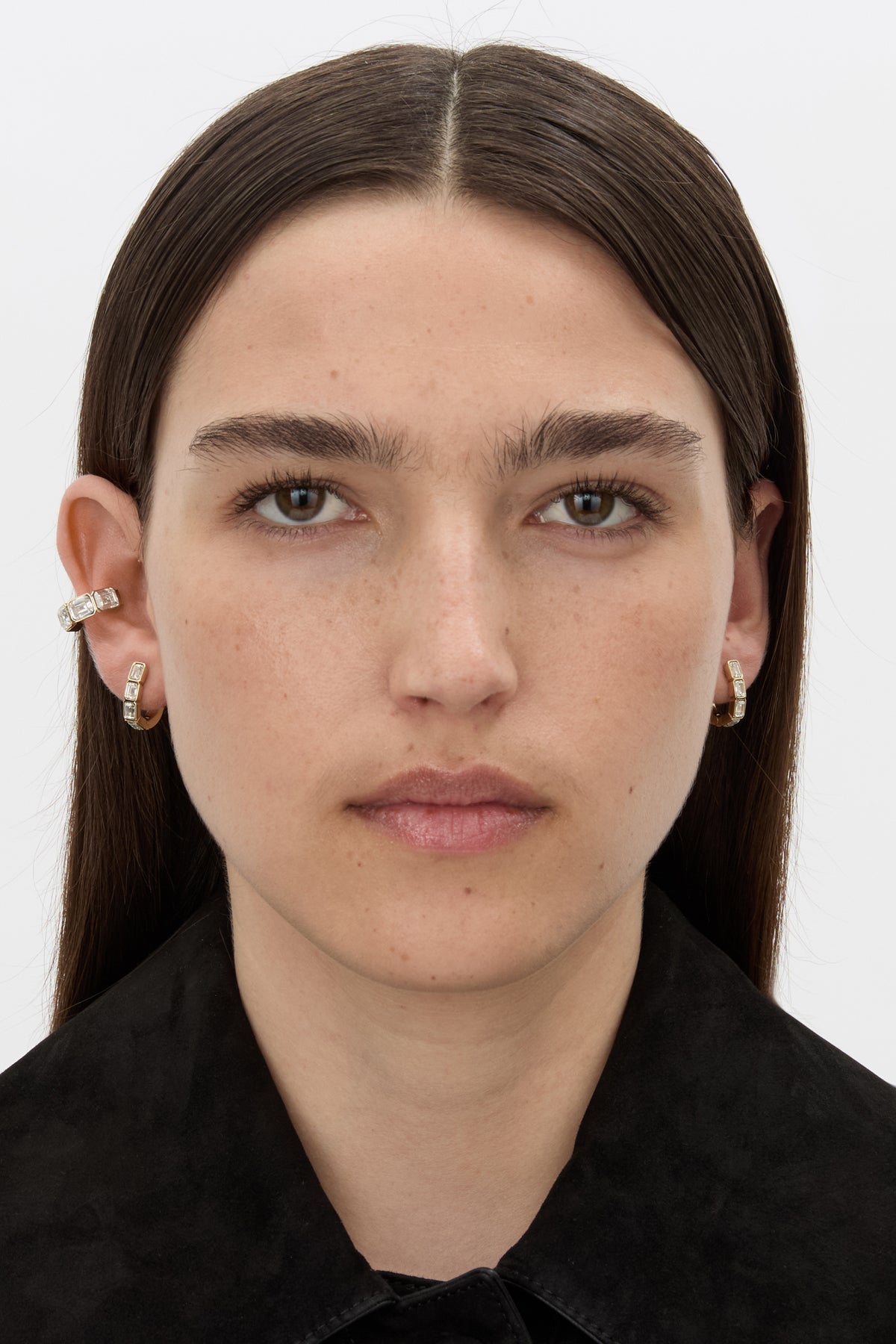Front-styled view CAMILLA AND MARC Leighton Huggies in 18k gold finish with emerald cut cubic zirconia stones.