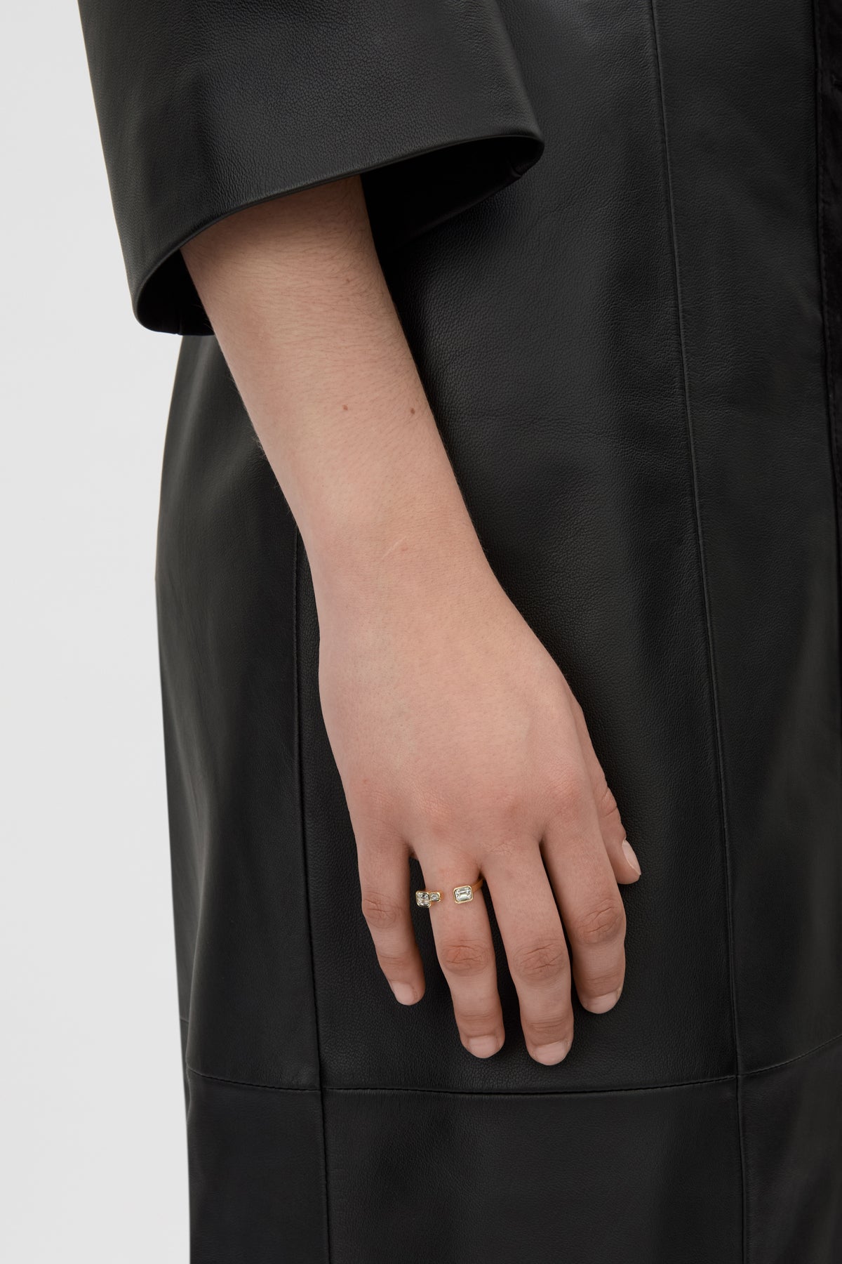 Styled view CAMILLA AND MARC Leighton Open Ring in 18k gold plating with emerald cut cubic zirconia stones.