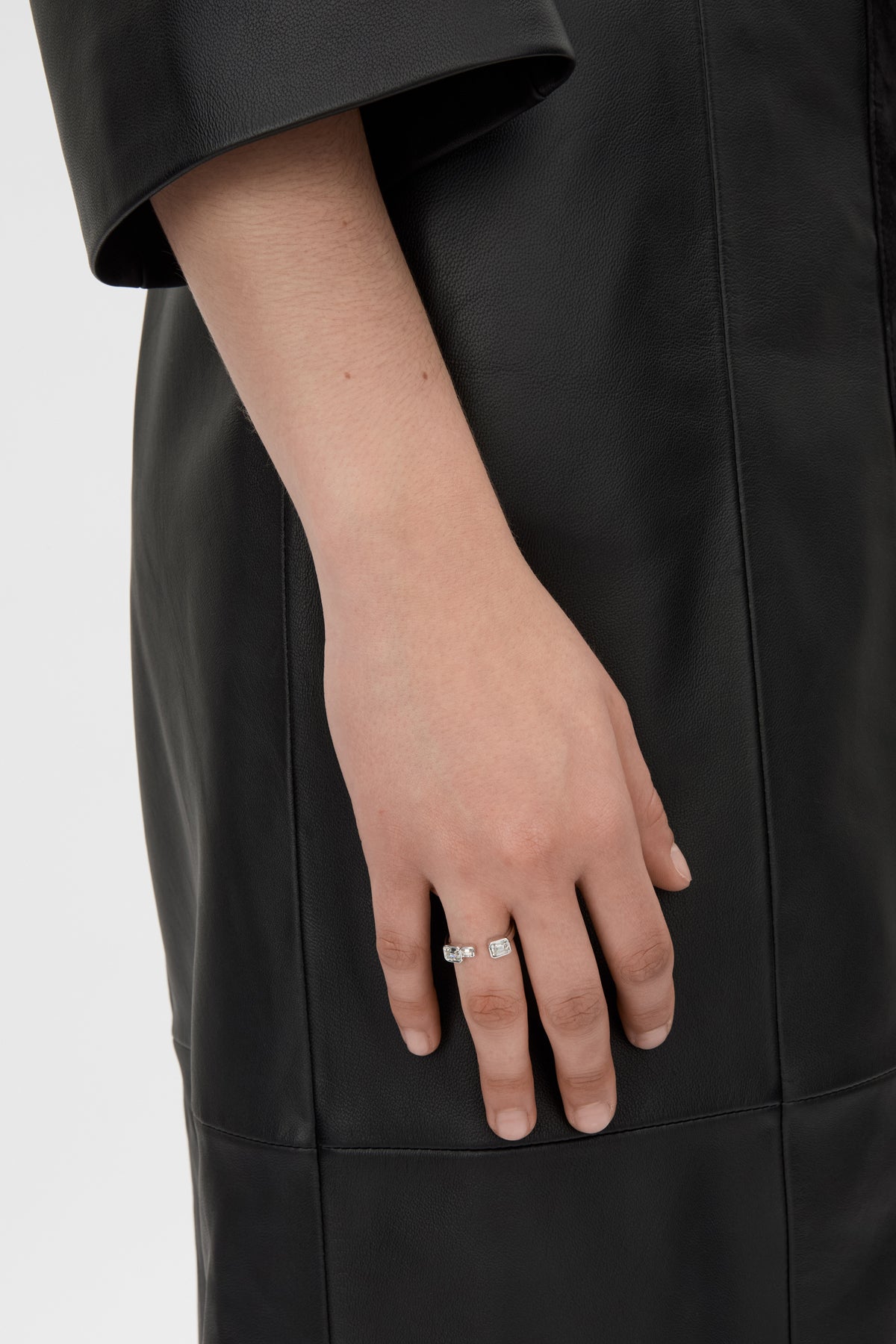 Styled view CAMILLA AND MARC Leighton Open Ring in silver with emerald cut cubic zirconia stones.