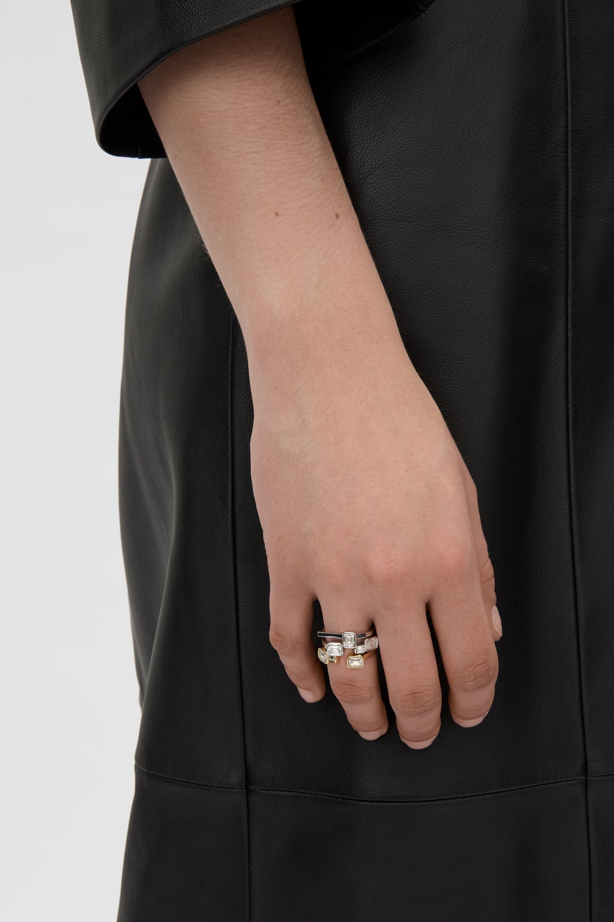 Front-styled view CAMILLA AND MARC Leighton Ring in silver finish with an offset emerald cut cubic zirconia stone.