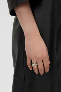 Front-styled view CAMILLA AND MARC Leighton Ring in silver finish with an offset emerald cut cubic zirconia stone.