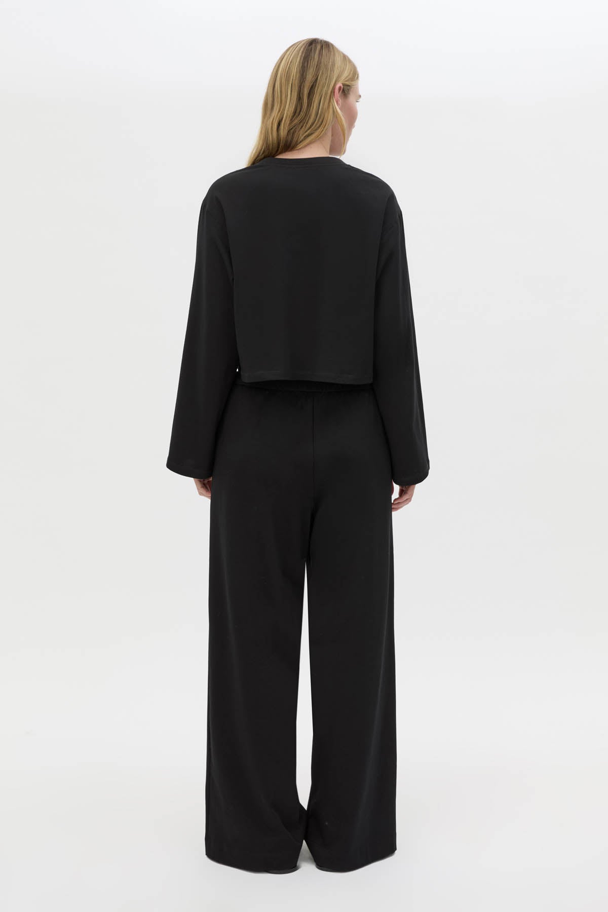 Back view CAMILLA AND MARC Niami Crochet Cropped Top in black with cut‑away crochet detailing at hem.