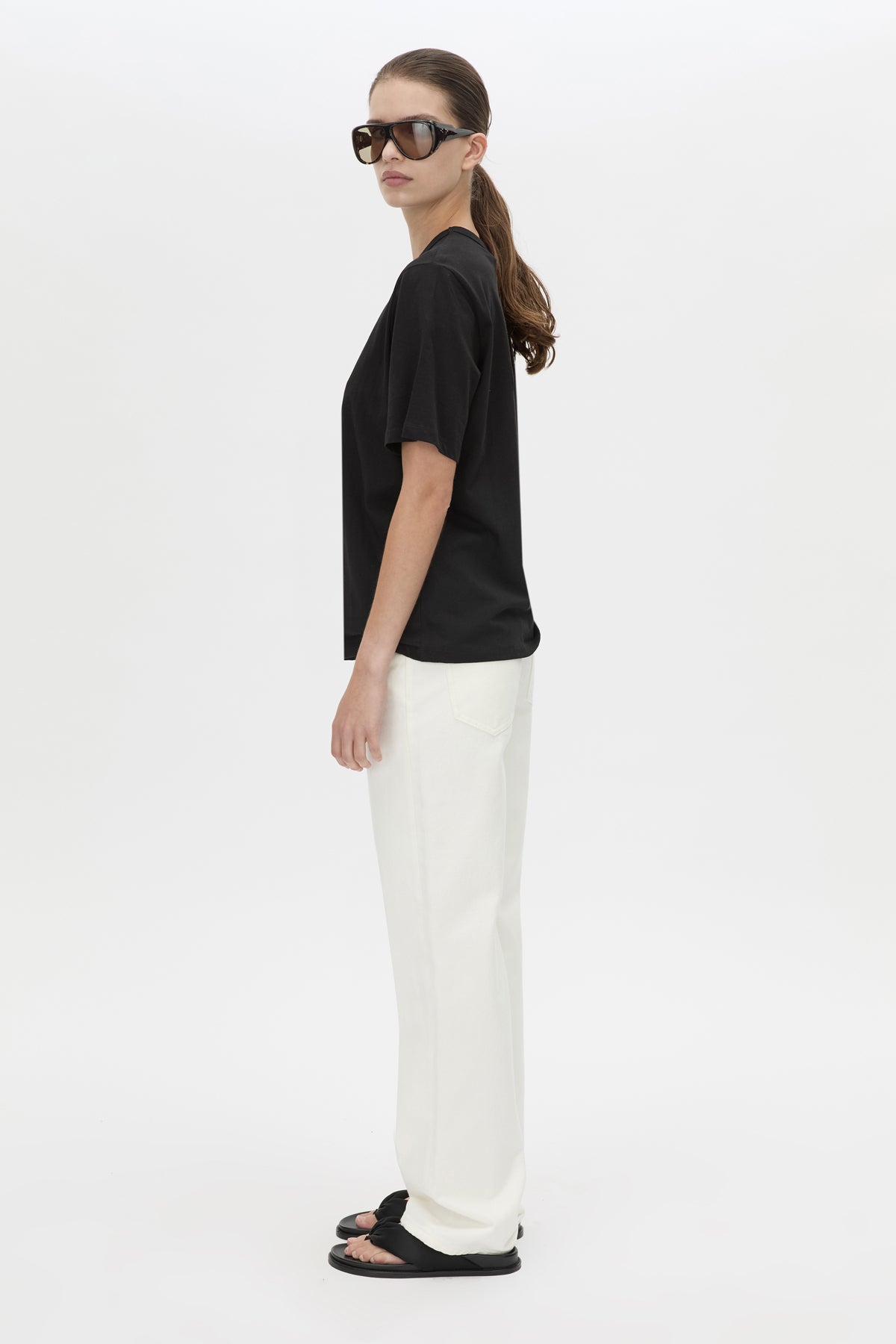 Side view CAMILLA AND MARC relaxed Olympia Print Tee in black with white plastisol artwork at centre back.