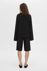 Back view CAMILLA AND MARC Peretti long-sleeve black tee with wide, shaped sleeves.
