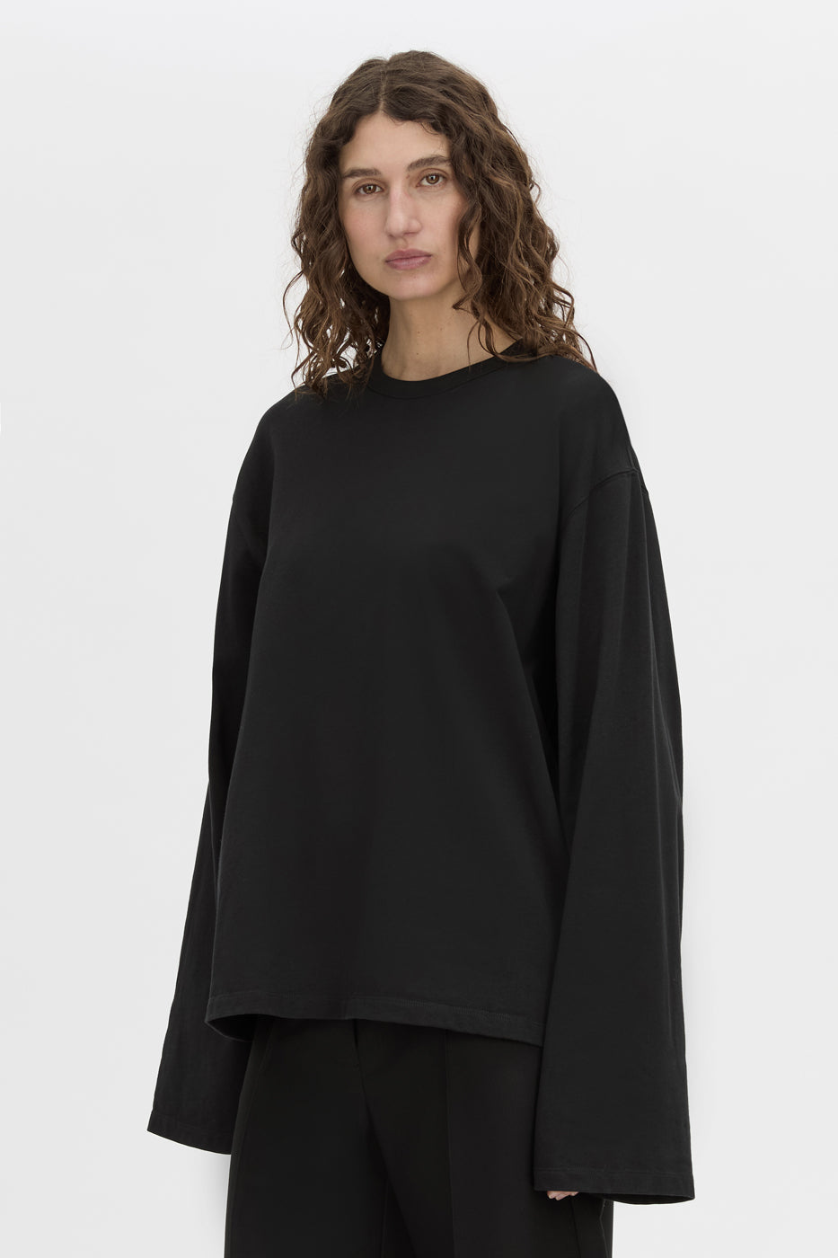 crop view CAMILLA AND MARC Peretti long-sleeve black tee with wide, shaped sleeves.