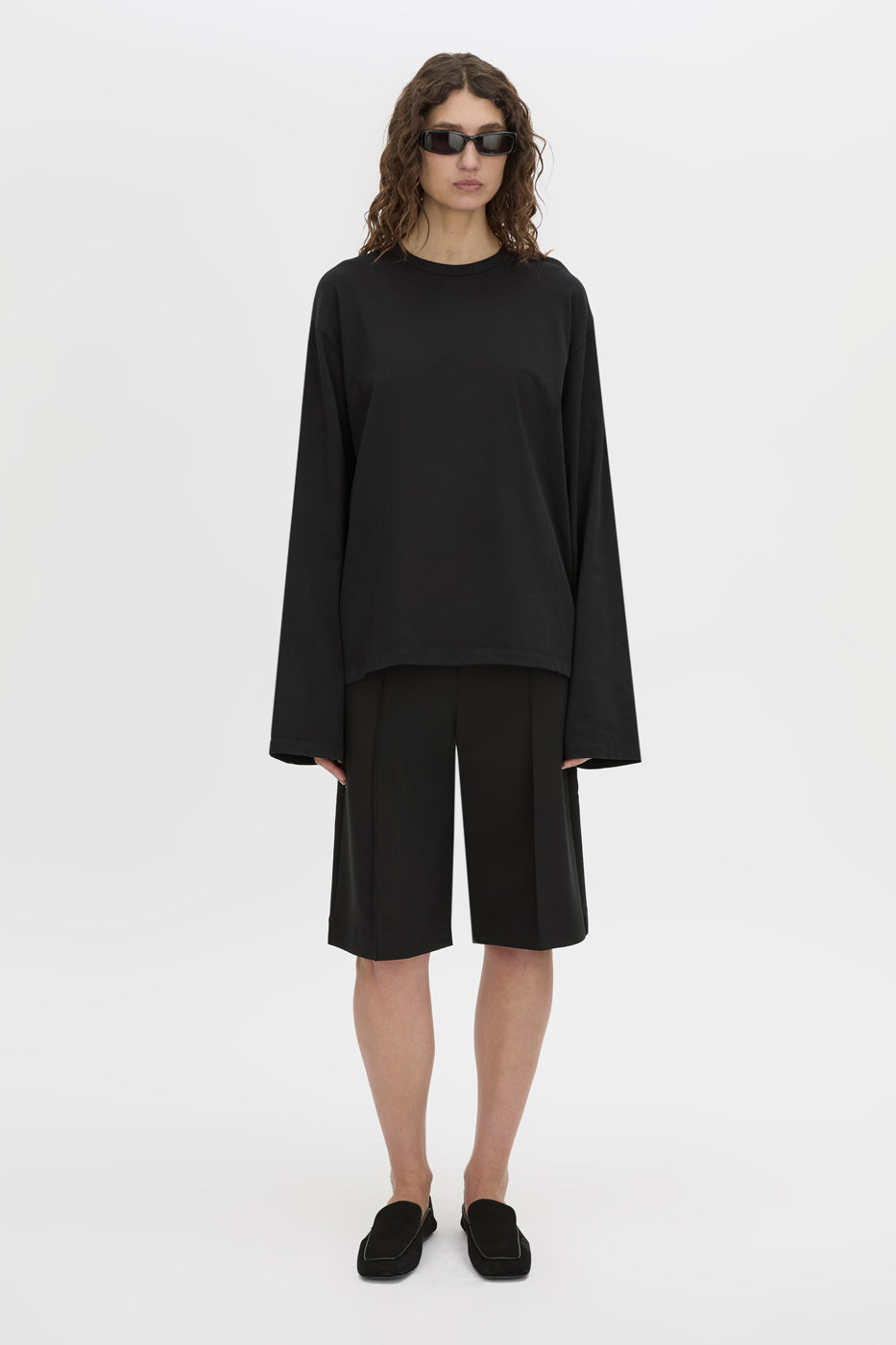 Front-styled view CAMILLA AND MARC Peretti long-sleeve black tee with wide, shaped sleeves.