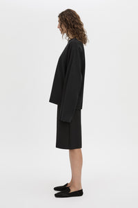 Side view CAMILLA AND MARC Peretti long-sleeve black tee with wide, shaped sleeves.