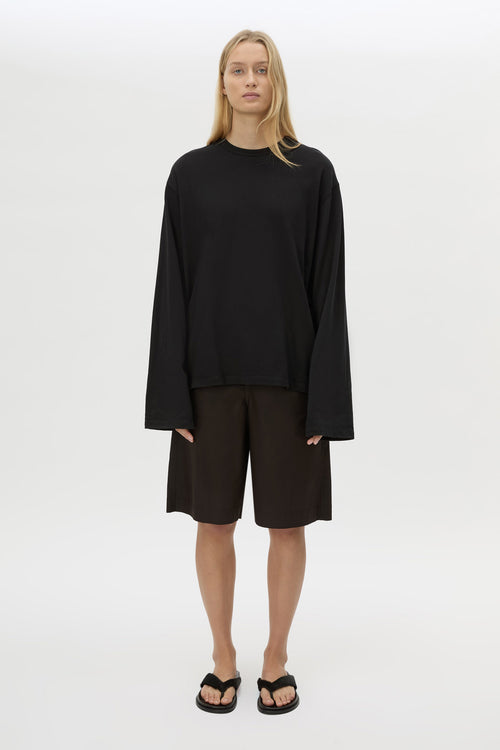 Front view with shorts CAMILLA AND MARC Peretti Long Sleeve Tee in Black with wide shaped sleeves.  
