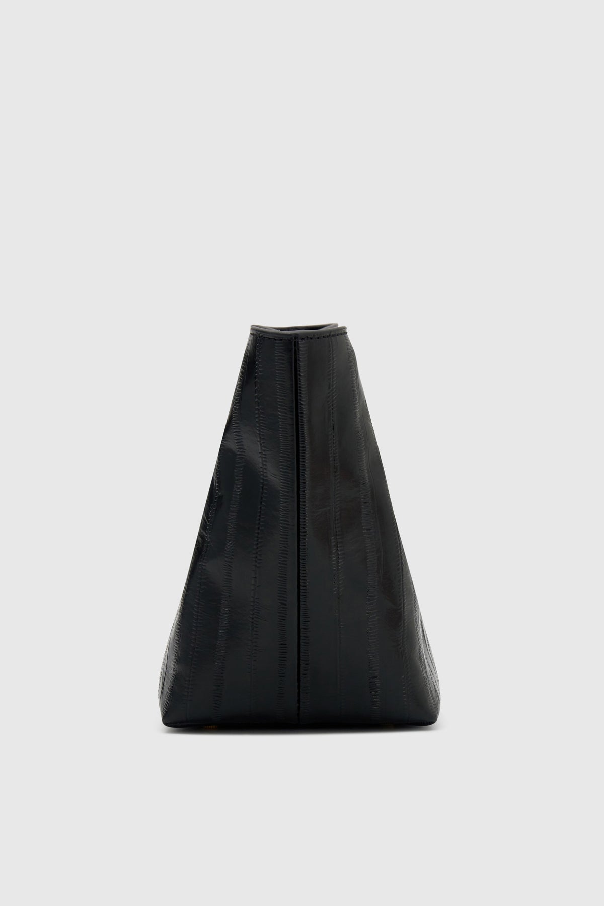 Side ghost view CAMILLA AND MARC Poppy Eel Clutch in Black eel‑embossed leather with ribbed gold hardware.