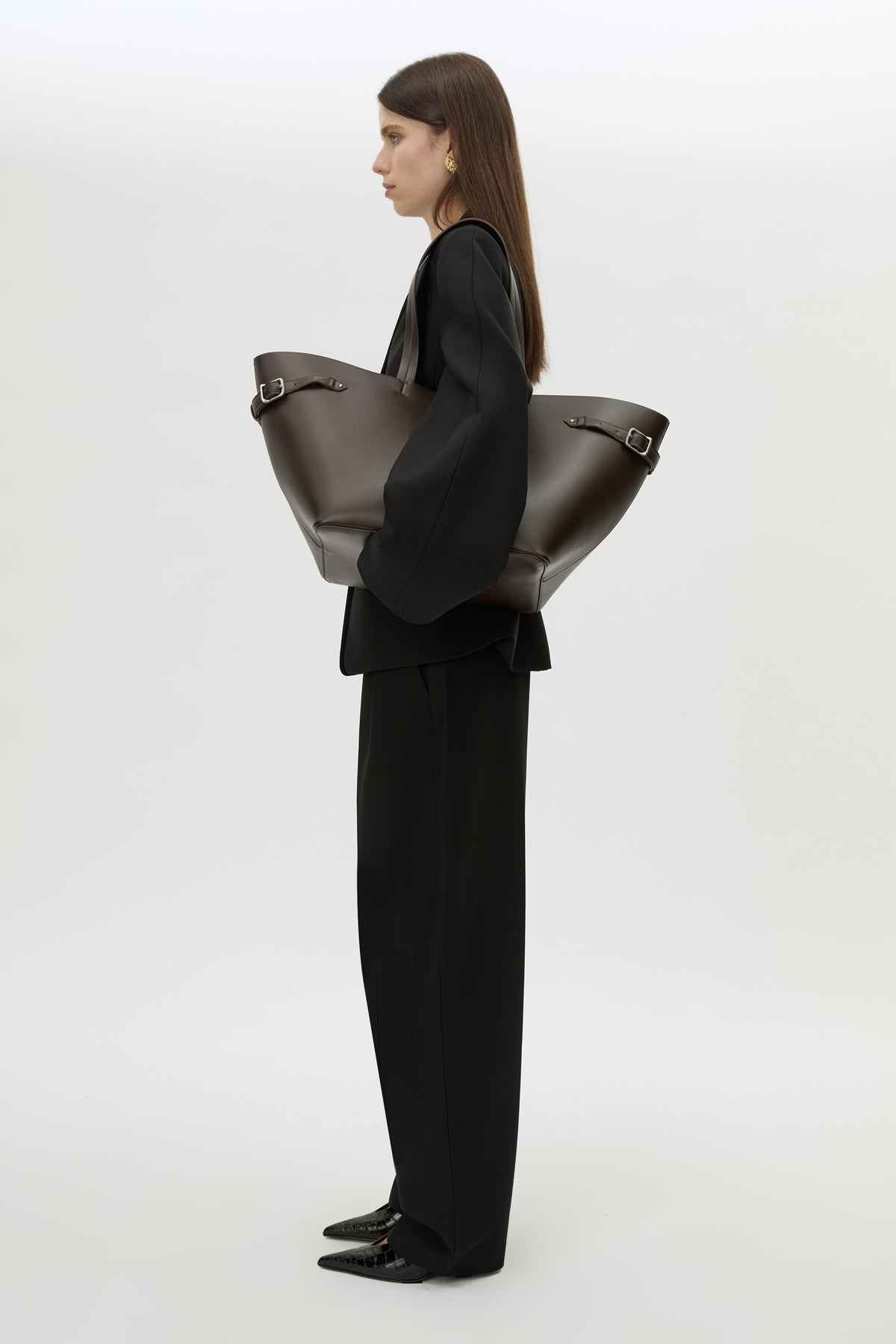 Styled view CAMILLA AND MARC Willa Tote in Chocolate Brown with side strap and buckle detailing and magnetic button closure.